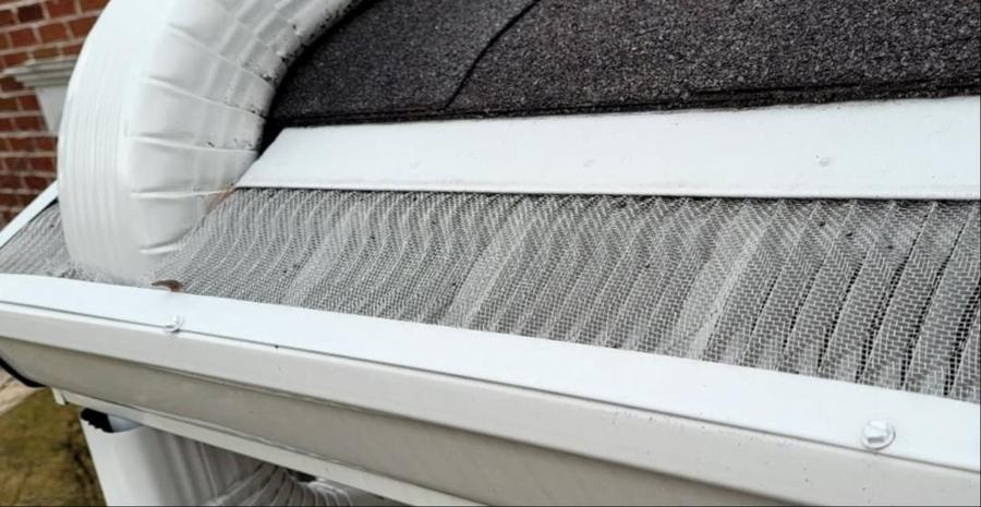 White Valor Gutter Guard installed on a gutter beside a downspout